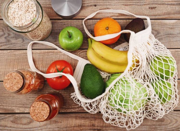 frukt och grönsaker samt fullkornsprodukter med fibrer och vitaminer för hälsosam kost i en nätpåse