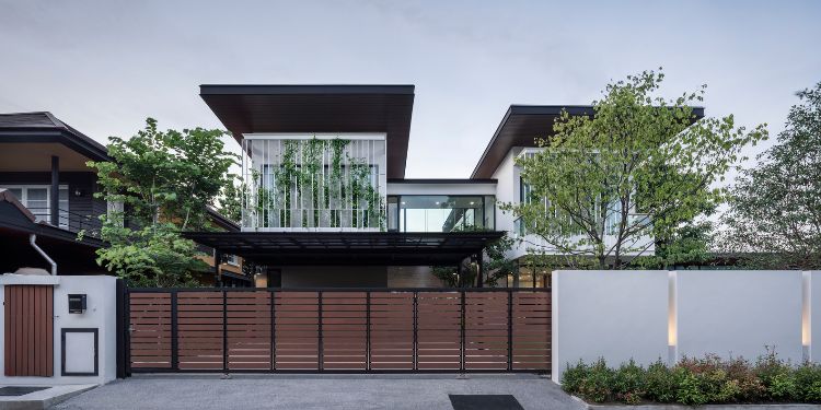 grön fasad designer hus modern arkitektur glas terrass naturlig miljö träd gräsmatta vax blomma front view gate garage