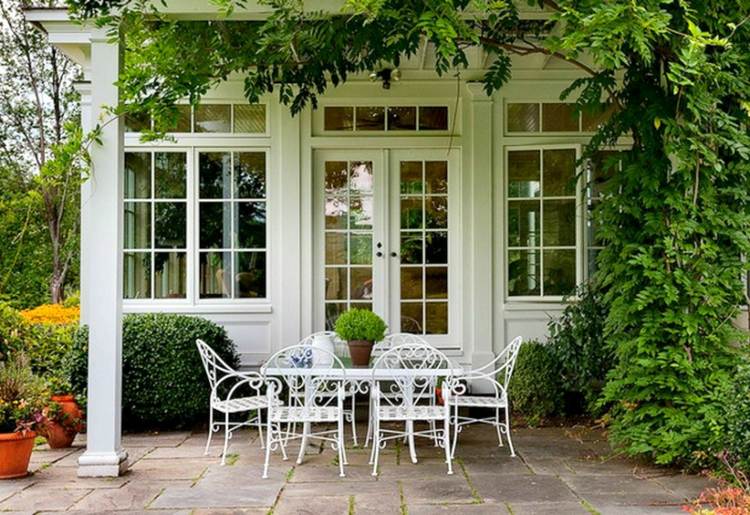 smidesjärn i trädgården vitt matbord terrass vintage design