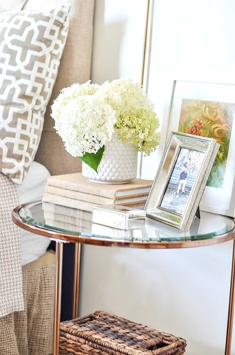 Sängbord dekoration idéer glasbord växter tavelramar sängkläder