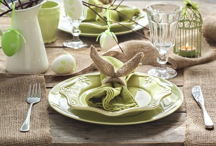 Påskdekoration på bordet grönt-porslin-set-jute tyg-servettring-kaninöron-tie-tyg servett