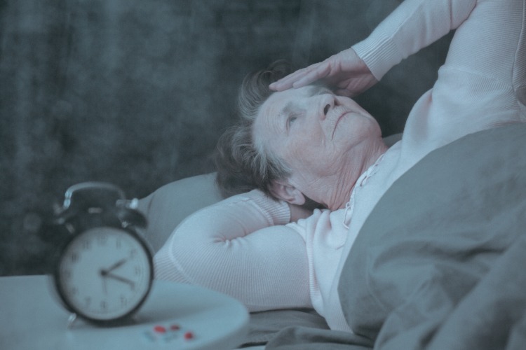 äldre kvinna lider av sömnlöshet mitt i natten