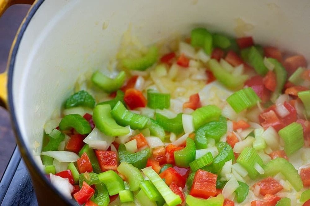 färska grönsaker som selleripaprika och lök i grytan som ingredienser för snabb soppa