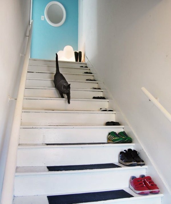 svart-katt-skor-på-trappor-blå-dörr