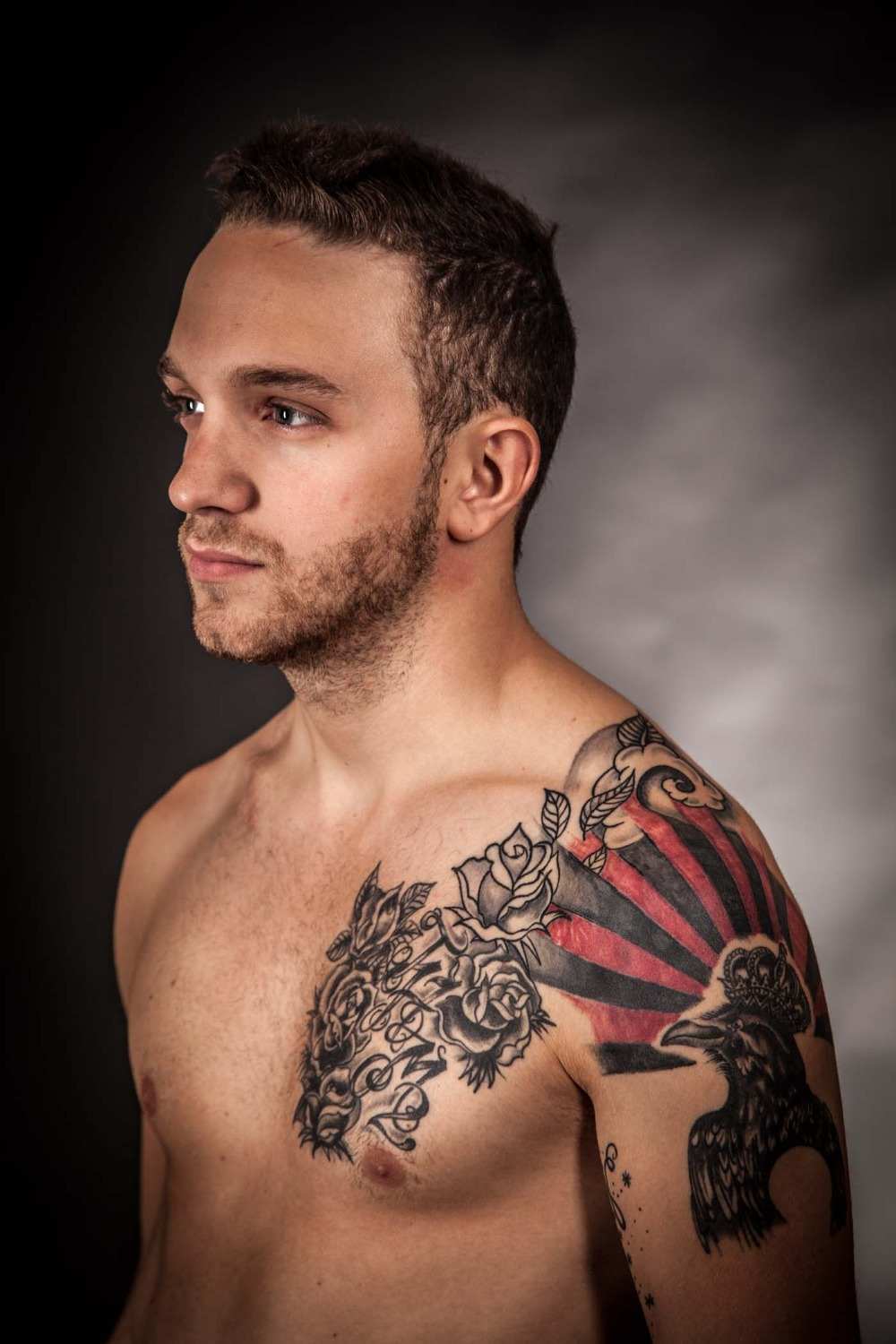tatuering bröst axelarm man kontrast med rödfärgade rosor kråka