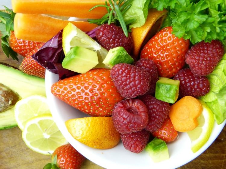 hälsosamma frukter och grönsaker som avokado samt morötter och frukter som jordgubbar och hallon