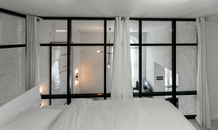 rum svartvitt inredning sovrum loft lägenhet modern glasvägg svart stålram