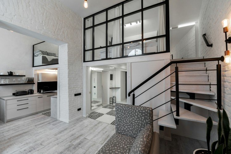 svartvitt inredning omshumelda ukraina lviv loft lägenhet öppet vardagsrum kök trappor entresol sovrum