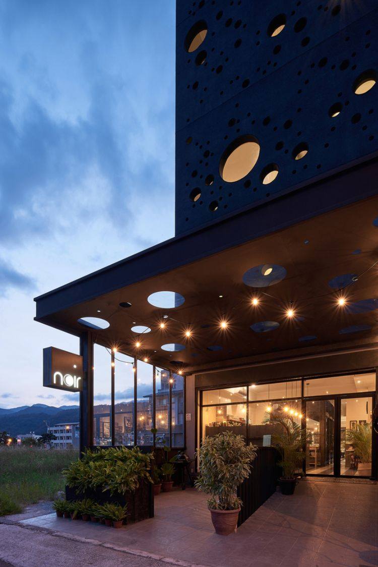 svart fasad modern design onyx upplyst hus taiwan minimalistiska runda hål design cirklar inspirerad av spray arkitektur projekt huvudentrén