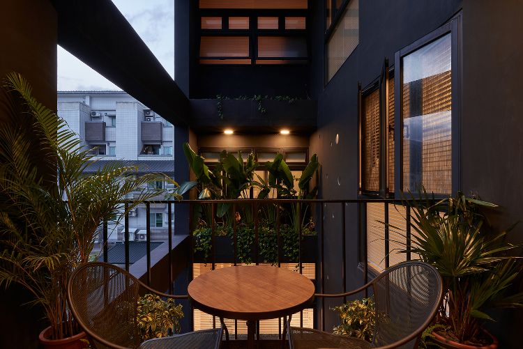 svart fasad modern design onyx upplyst hus taiwan minimalistiska runda hål design cirklar inspirerad av spray arkitektur projekt balkong växter