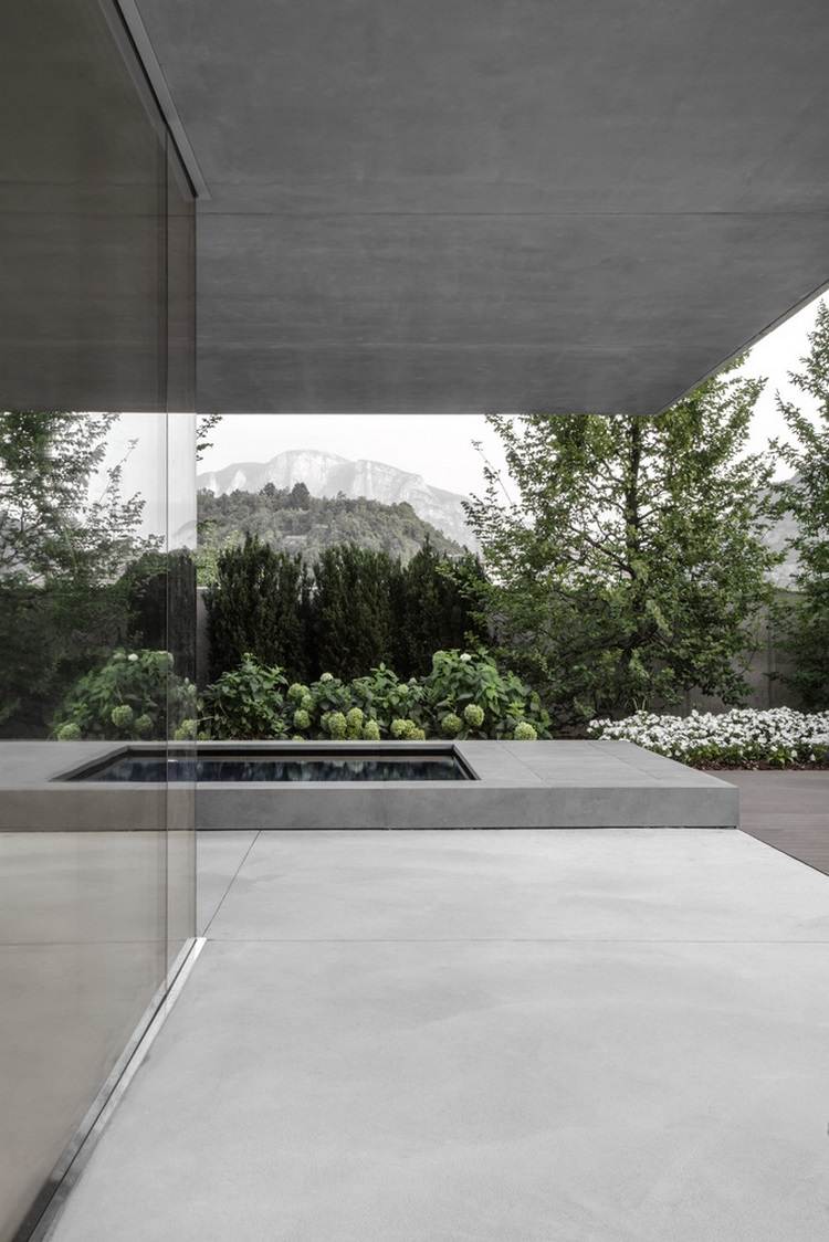 exponerat betonghus casa mf stora glasfönster modern minimalistisk design växter pool berg blommor