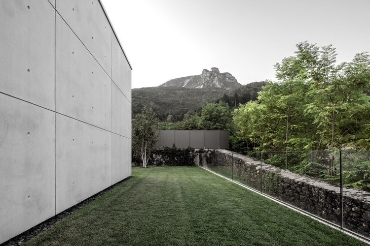 exponerat betonghus casa mf stora glasfönster modern minimalistisk designvy berg glasskyddsvägg fasad betongplattor