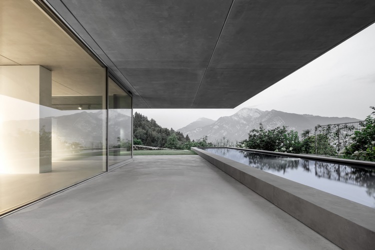 exponerat betonghus casa mf stora glasfönster modern minimalistisk design poolutsikt bergsfönster