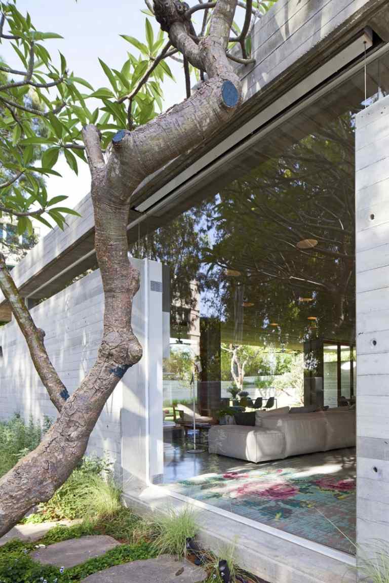 Exponerad betong inuti -glasvägg-eukalyptus-soffa-hus-trädgård-arkitekt-hus-modern-design