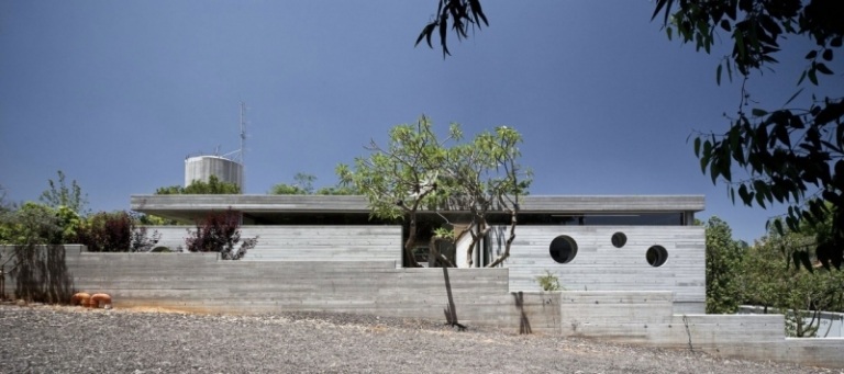 exponerad betong-interiör-arkitekt-hus-israel-kiselsteine-träd-eukalyptus-himmel-vackert-väder