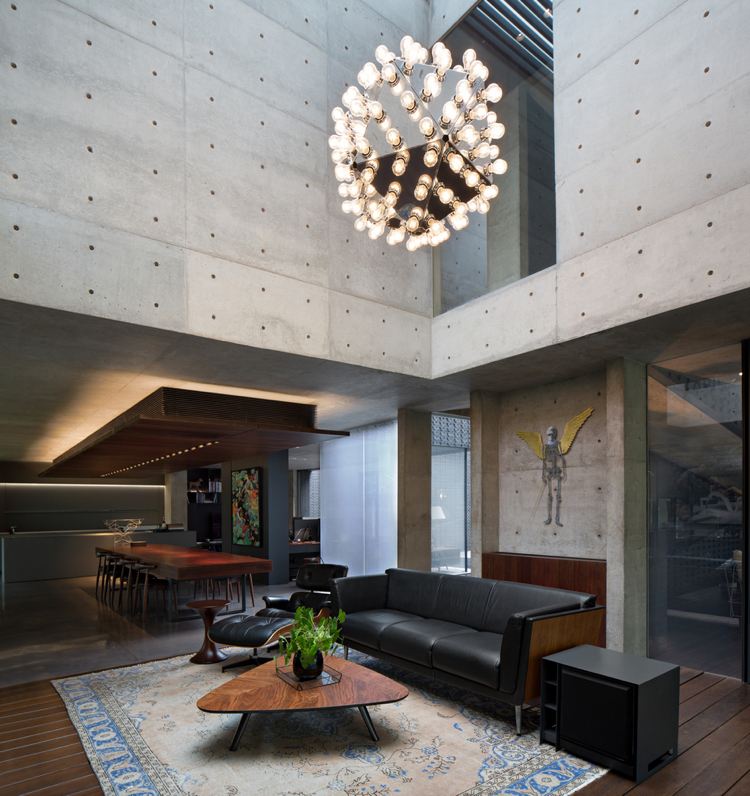 Betong innerväggar trä soffbord vardagsrum högt i tak modern ljuskrona