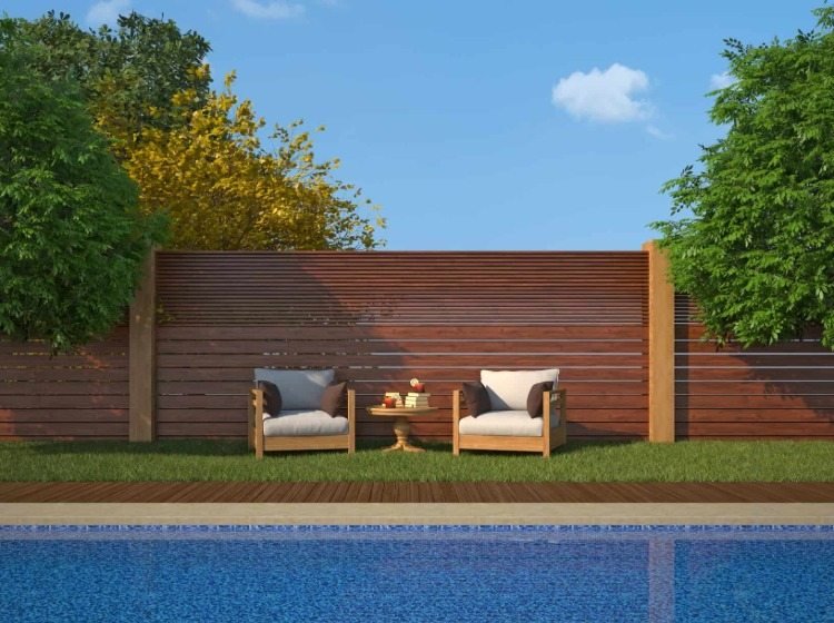 snyggt staket av trä som en sekretessskärm vid poolen med trädgårdsmöbler