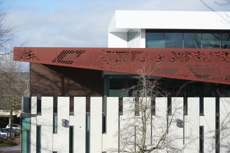 Sekretessstängsel-metall-fasad-ellement-röd-stål-mönster-perforerad-gabaeude-vit
