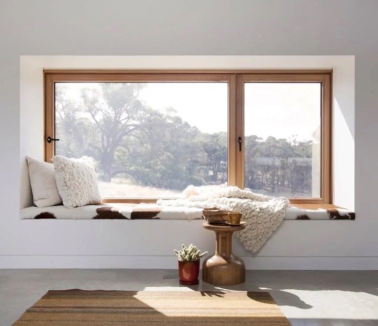 Bygg fönster och ordna en plats med en mysig filt och kuddar och ett soffbord