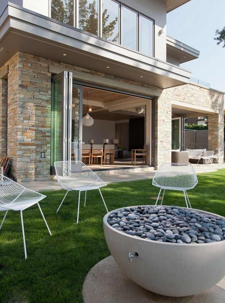 öppen spis-trädgård-sittplatser-hus-lägenrn-utomhus-stolar-metall-vit-gräsmatta-natursten