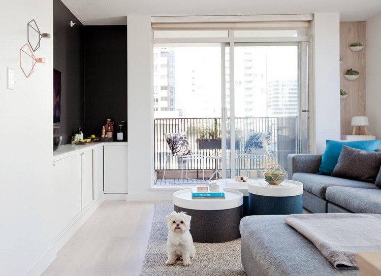 Skandinaviskt möblerat vardagsrum-ljust trägolv-grå-soffa-svart-vägg färg-nisch