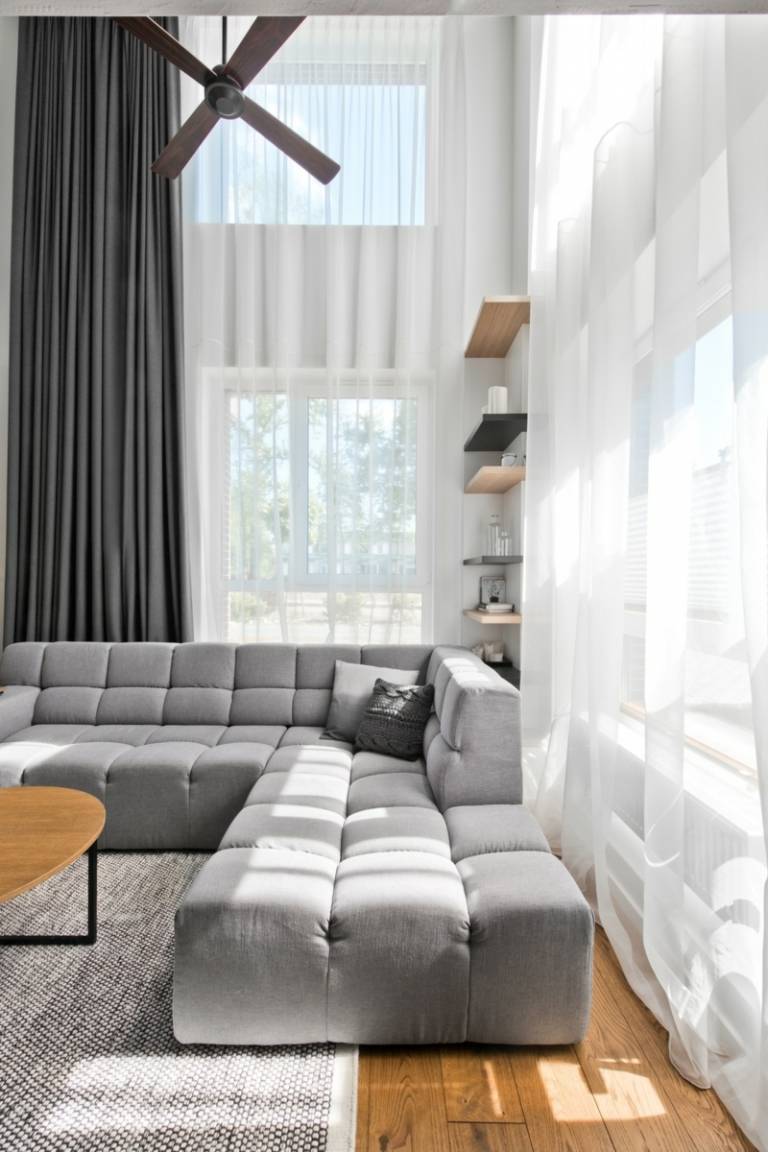 Skandinavisk stil grå stoppade hörnsoffa vita gardiner möbler