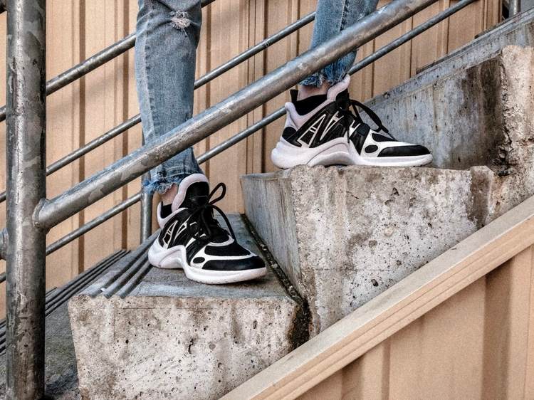 svartvita sneakers ankelhöga i kombination med jeans som herrmode och gatukläder