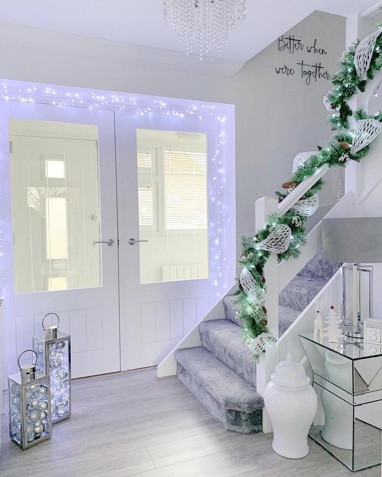 Juldekorationer i hallen med kallvita sagoljus och dekorationer i silver och vitt
