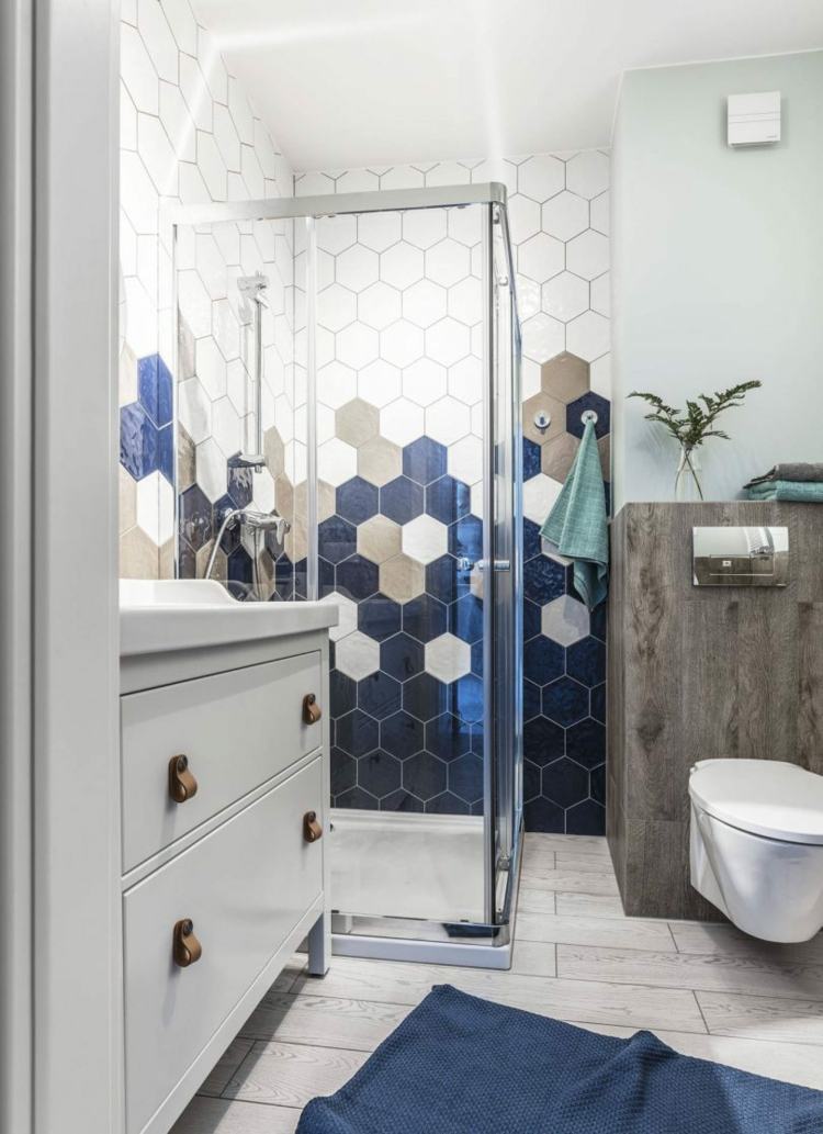 Attraktiv badrumsidé med blå hexagonplattor och vita möbler