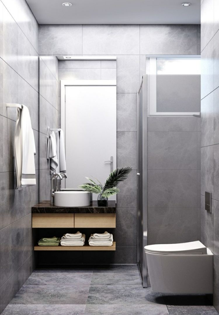 Minimalistisk och svartvit i grått med en praktisk uppdelning av dusch, toalett och handfat
