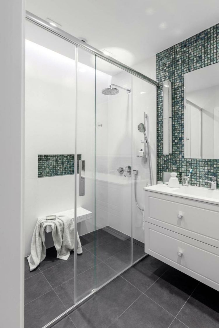 Stort våtrum, gröna mosaikplattor och vita badrumsmöbler