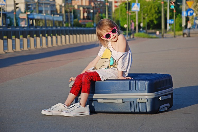 Semester med barn flicka sitter på resväskan vad du bör vara uppmärksam på