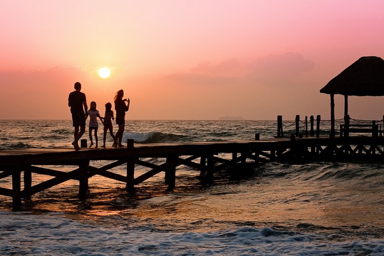 Familj vid havet med barn solnedgång