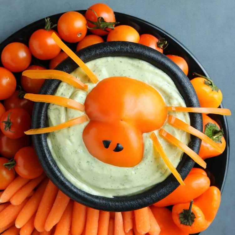 Halloween grönsaksfat med dopp med spindel av tomater och morötter