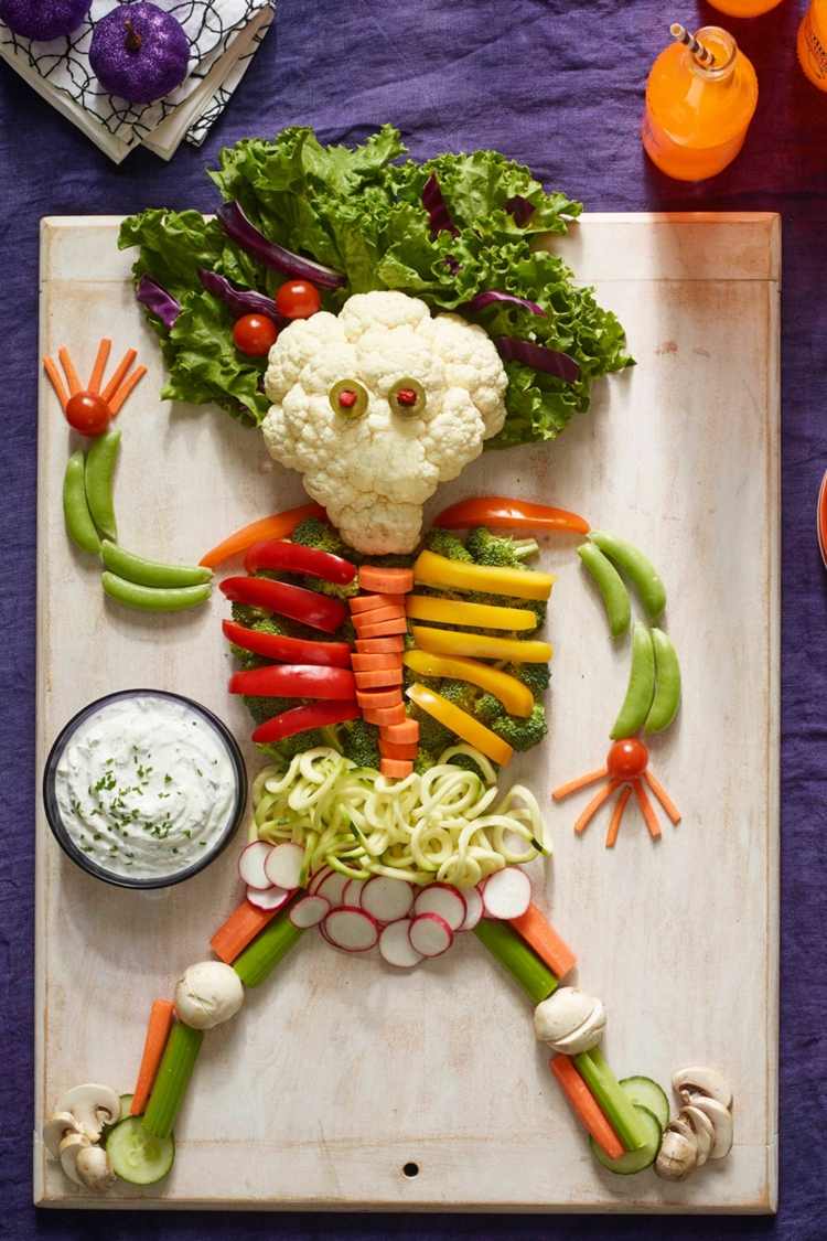 Halloween -idé för ett skelett av grönsaker och örtdopp