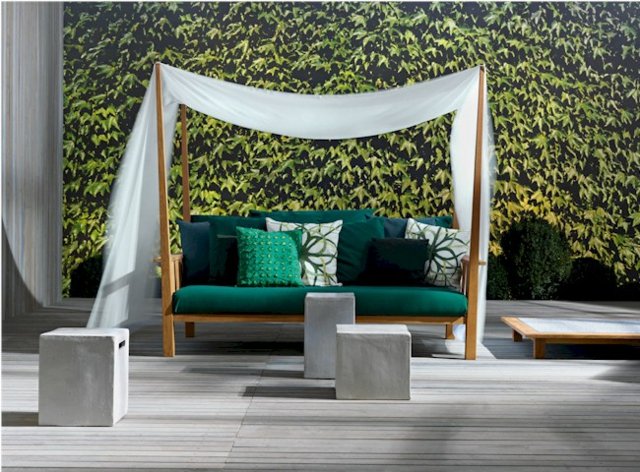 Två-sits soffa solskydd dekorativa kuddar vintergröna växter