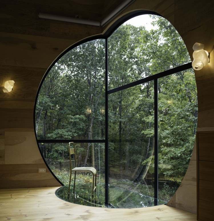 sol-hus-trä-stort-runt-fönster-iögonfallande-design