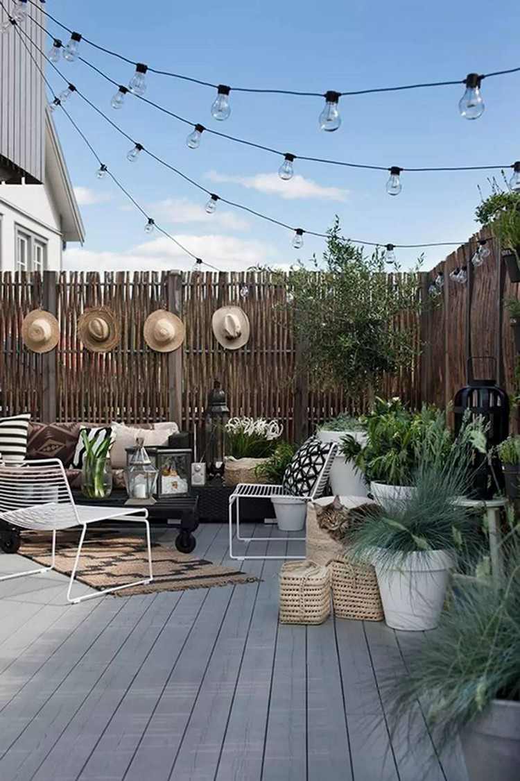 Sommardekoration för terrasshalmhattar på staketet gröna växter i krukor