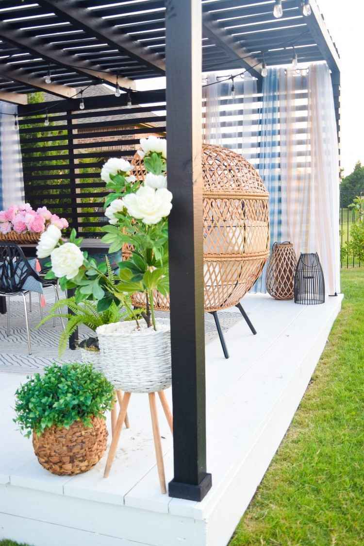 Täckt terrass på sommaren dekorera med blommor och gardiner