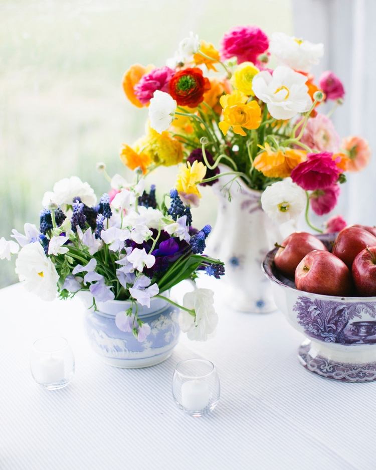 Sommardekoration med blommor i vaser och tekoppar