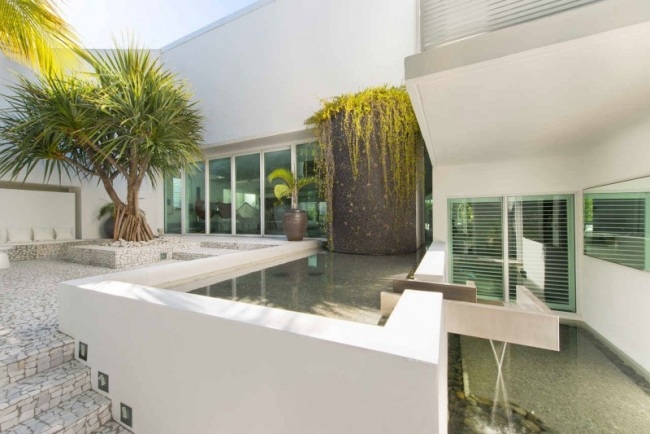 Designa den asymmetriska innergården i ett hus med en vit fasad