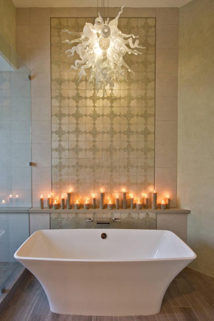Badrum i spansk stil med guldplattor och LED-ljus och ett fristående badkar