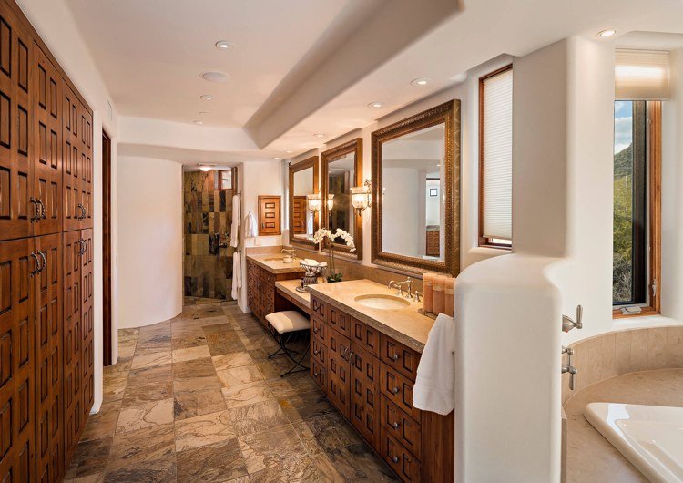 Spanskt badrum med naturstenskakel och vintage badrumsskåp