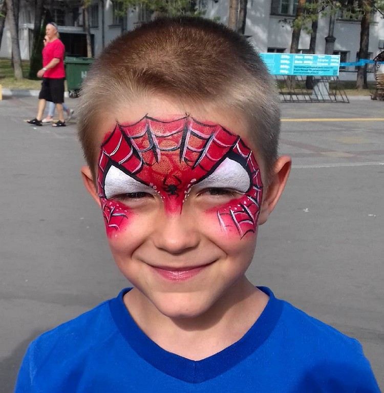 barn som spiderman som applicerar smink halloween barnfest
