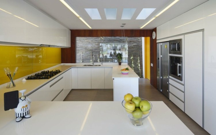 Stänkskydd-spis-akrylglas-plast-gul-arbetsyta-glasdörrar-fruktskål-äpplen-kylskåp-väggklocka-takbelysning