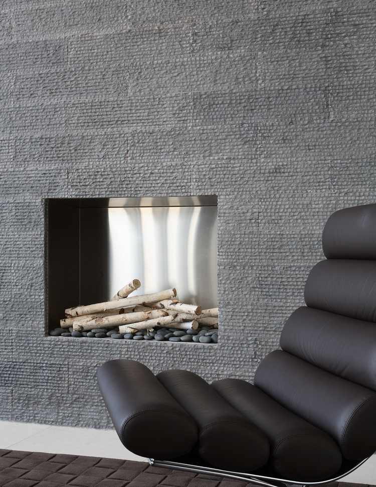 grå stenplattor för väggbeklädnad med integrerad öppen spis och moderna designfåtöljer i läder