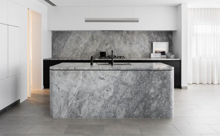 terrazzo köksö och kök bakvägg klädd med ett marmorlook i grått med vita köksskåp
