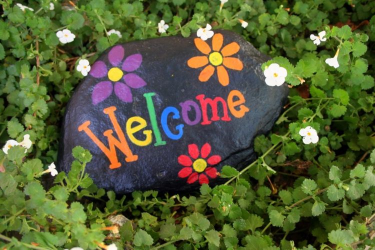 sten-figurer-trädgård-välkommen-entré-dörr-dekoration-färgglada-blommor