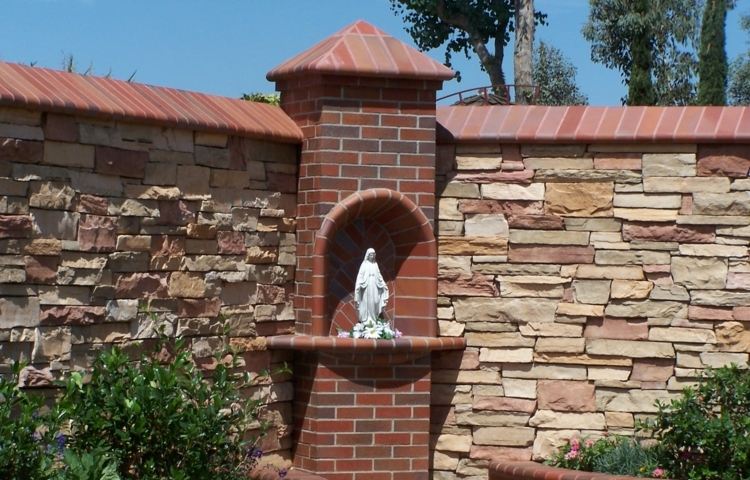 stenmur i trädgården pelare tegel maria staty plattor