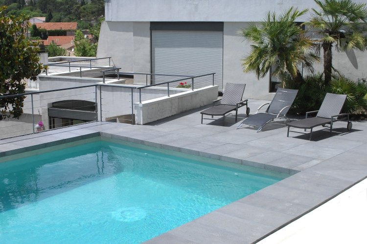 sten-plattor-terrass-terrass plattor-grå-pool-solstolar-palmer-moderna